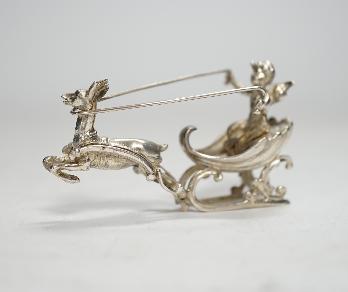 A late 19th century Hanau miniature silver model of a deer pulling a sleigh with cherub, by Berthold Muller, import marks for Chester, 1899, length 64mm.